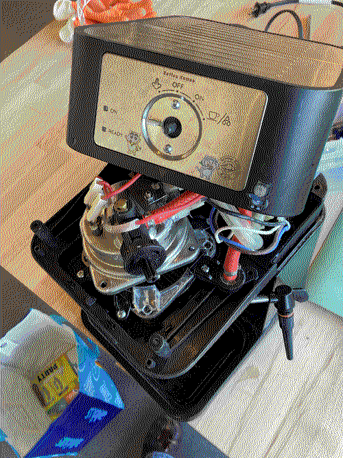 a disassembled espresso machine, showing wires, pipes, and a metal boiler